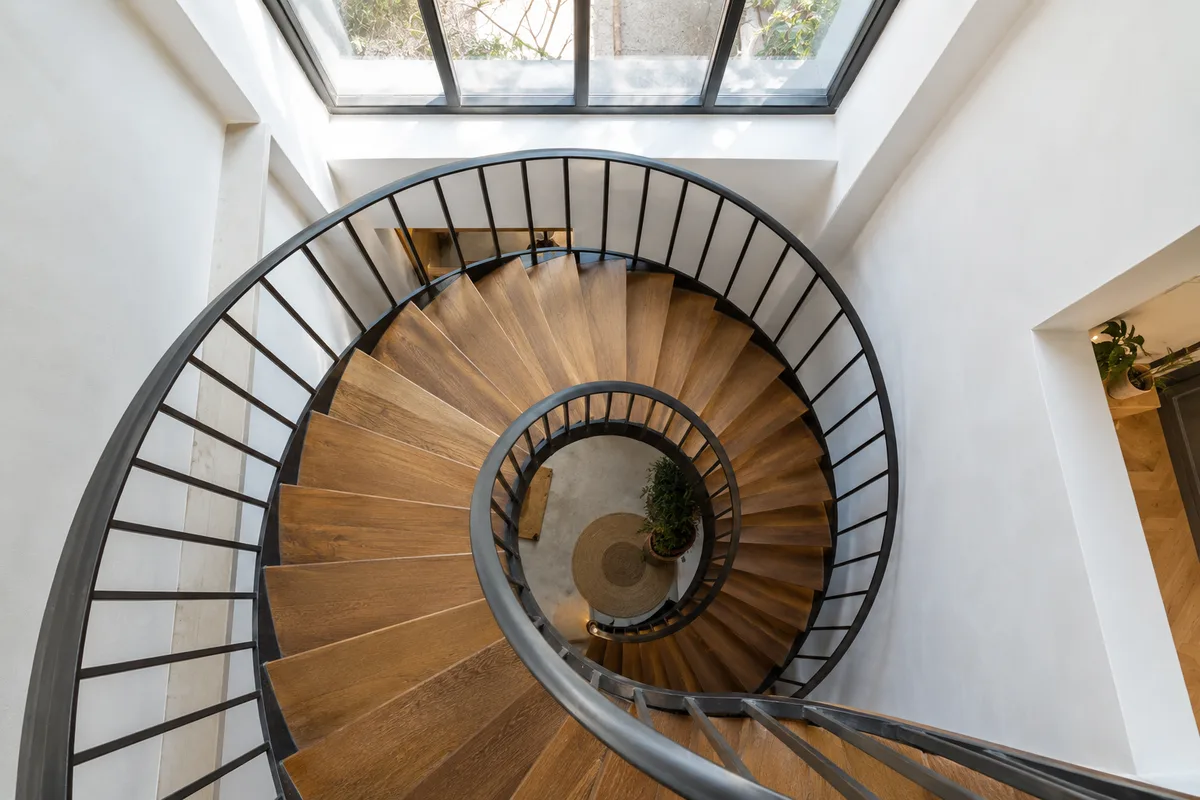 Escalier en colimaçon vu d’en haut, perspective en spirale sous une lumière douce